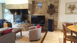 sala de estar con TV y chimenea en Le BOCAGE, en Sartilly