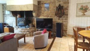 a living room with a television and a fireplace at Le BOCAGE in Sartilly