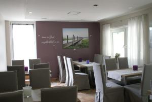 a dining room with tables and chairs and windows at Hotel Storchen in Rheinfelden