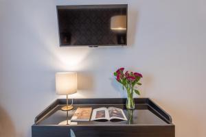 a table with a lamp and a vase with flowers at 3110 ArtHotel in Florence