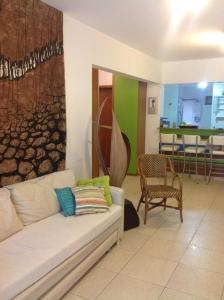 a living room with a white couch and chairs at Lindo ap dentro da riviera mód 8 pertinho da praia área de lazer completa in Riviera de São Lourenço
