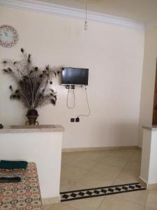 a living room with a tv on the wall at Al Oualidia Dar Diafa in Oualidia