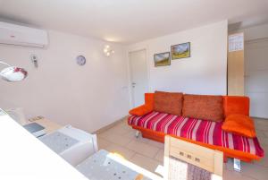ein Wohnzimmer mit einem orangenen Sofa in einem Zimmer in der Unterkunft Studio Southwest in Ljubljana