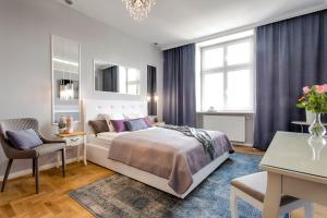 1 dormitorio con cama, escritorio y silla en Main Square Apartments, en Cracovia