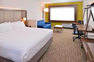 a hotel room with a bed and a projection screen at Holiday Inn Express & Suites Madison, an IHG Hotel in Madison