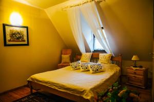 a bedroom with a bed with yellow walls and a window at Pirčiupio Karčema in Pirčiupiai