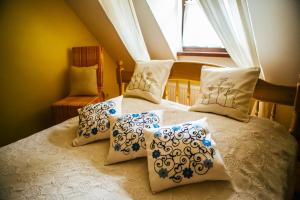 ein Schlafzimmer mit einem Bett mit Kissen und einem Fenster in der Unterkunft Pirčiupio Karčema in Pirčiupiai