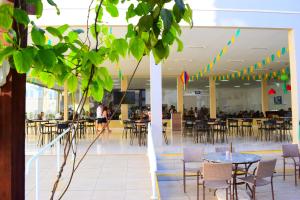 un ristorante con tavoli e sedie e persone sullo sfondo di Encontro das Águas Thermas Resort by WAM Experience a Caldas Novas