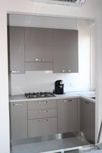 a kitchen with white cabinets and a tea kettle on the stove at IR Panoramic in Trieste