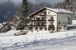 ein Gebäude im Schnee vor einem Berg in der Unterkunft Hotel Berghaus in Wengen
