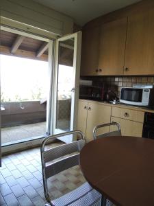 a kitchen with a table and chairs and a microwave at N. Blaise Chambres d'Hôtes in Estavayer-le-Lac