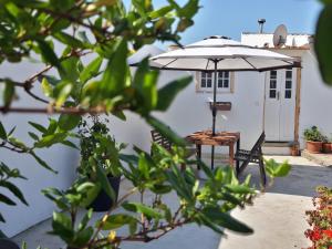 einen Tisch und einen Regenschirm auf einer Terrasse in der Unterkunft Cozy Place in Sintra