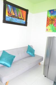 uma televisão numa parede acima de um banco com duas almofadas em Apartamento Tolu em Tolú