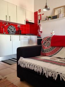 a kitchen with white cabinets and a red wall at Casa da Pedra - Aljezur, always the sun in Aljezur