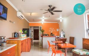 Hotel Terra Viva في Quesada: غرفة طعام مع جدران برتقالية ومروحة سقف