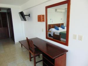 1 dormitorio con escritorio, espejo y cama en Hotel Rosita en Puerto Vallarta