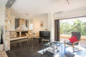 a living room with a tv and a fireplace at Modern Condo at the Beach in Sounio