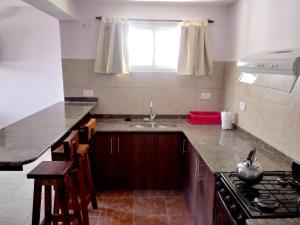 uma cozinha com um lavatório e um fogão em Casa en Mina Clavero em Mina Clavero