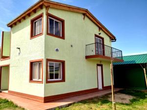 uma casa verde e branca com janelas vermelhas em Casa en Mina Clavero em Mina Clavero