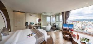 a bedroom with a large bed and a large window at New Sun Hotel in Nha Trang