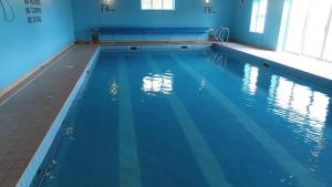 a swimming pool with blue water in a building at Caherush Lodge in Quilty