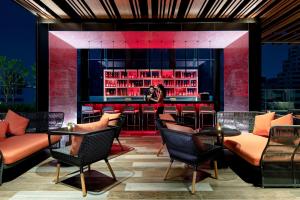 a bar at a restaurant with a woman taking a picture at Novotel Bangkok Sukhumvit 4 in Bangkok