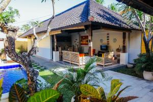 ein Haus mit einem Pool neben einem Resort in der Unterkunft Villa Matahari in Seminyak