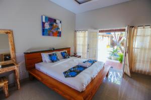 ein Schlafzimmer mit großem Bett und Fenster in der Unterkunft Villa Matahari in Seminyak