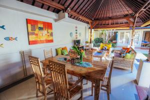 ein Esszimmer mit einem Holztisch und Stühlen in der Unterkunft Villa Matahari in Seminyak