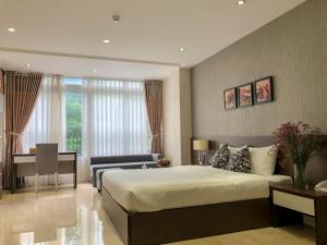 a bedroom with a bed and a table and a desk at Sunny Serviced Apartment in Ho Chi Minh City