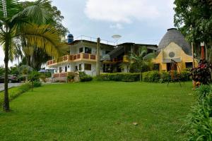 a house with a grass yard in front of it at Hotel Faroazul RNT12633 in Santa Rosa de Cabal