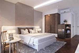 a bedroom with a large white bed and a table at Ha Noi Hotel near Tan Son Nhat International Airport in Ho Chi Minh City