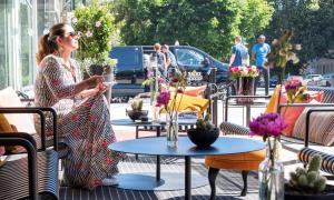 a woman standing on a patio with tables with flowers at Best Western Plus Time Hotel in Stockholm