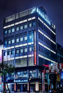 een hoog gebouw met een bord ervoor bij Hotel Lainn in Kaohsiung