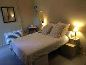 1 dormitorio con 1 cama blanca y 2 lámparas en Agape Du Gers, en Montréal