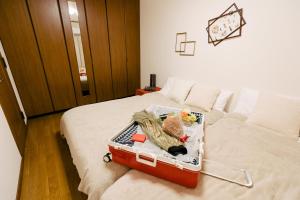 ein Koffer auf einem Bett in einem Zimmer in der Unterkunft Kashikiri Ikkenya Sora in Osaka
