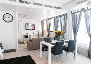 a living room with a table and chairs and a clock at Hotelli & Ravintola Martinhovi in Raisio