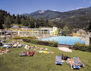 a group of people laying on lawn chairs at a resort at Hotel Gailberghöhe in Kötschach
