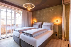 dwa łóżka w pokoju z dużym oknem w obiekcie HOTEL SEPP - Alpine Boutique Hotel - Adults Only ab 21 Jahre w mieście Maria Alm am Steinernen Meer +37 zdjęć
