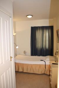 ein kleines Schlafzimmer mit einem Bett und einem Fenster in der Unterkunft Alléhotellet in Finspång