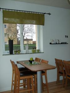 a dining room table with chairs and a window at Alléhotellet in Finspång