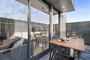 un balcón con una mesa con copas de vino. en Manhattan Apartments - Caulfield North en Melbourne