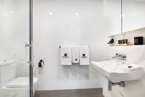 a white bathroom with a sink and a toilet at Manhattan Apartments - Caulfield North in Melbourne +39 photos