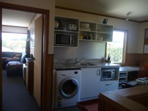 a kitchen with a washing machine and a sink at 49 on Jans Beach Break in Oakura