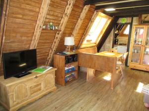 a living room with a television and a desk with a lamp at Auf die 12 - Auf die 13 in Freyung