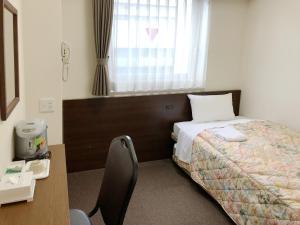a bedroom with a bed and a desk and a window at Osaka Academia in Osaka
