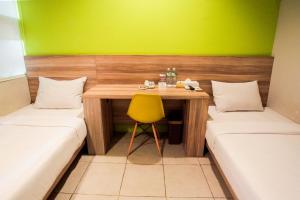 Tempat tidur dalam kamar di LeGreen Suite Supomo