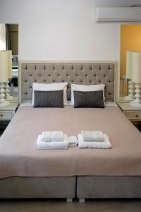 1 dormitorio con 1 cama grande y 2 toallas. en GreeceRent - LUX LADADIKA en Tesalónica