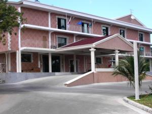 un gran edificio de ladrillo rojo con aparcamiento en Sunny Golf Tamatave, en Toamasina