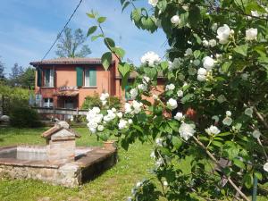 una casa con flores blancas delante de ella en Agriturismo Piccola Raieda en Sasso Marconi